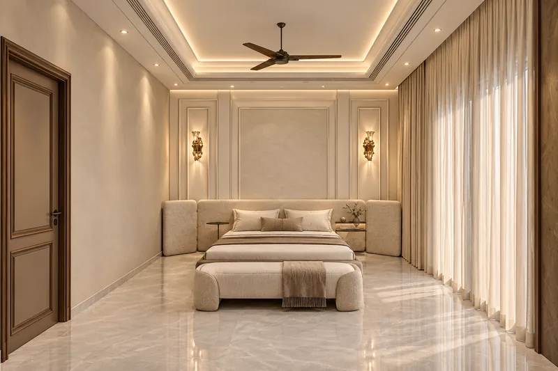 Bedroom with a wide cream upholstered headboard against a moulded panelled wall, wall sconces, a bench at the foot of the bed and sheer curtains
